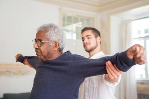 physical therapist helps older man
